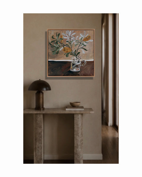 Framed artwork of Native Australian Banksia flowers with Brown toned background, on a wall above a console table with a lamp and bowl. This piece gives warm vibes, and creates a character filled interesting home