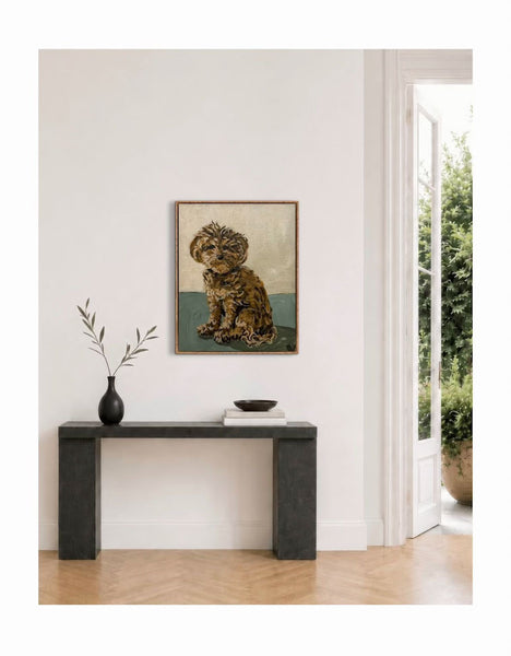 Framed artwork of a dog on a wall above a console table with decor items. Invoking feelings of love and warmth